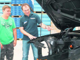 Ulrich Hotz, Mitarbeiter der Firma Feinwerktechnik hago GmbH, zeigt beim Ausbildungstag an einem Beispiel, am „Gehäuse“ eines 3-er BMW, welche Teile vom renommierten Küssaberger Unternehmen für die Autoindustrie gefertigt werden. Bild: Südkurier